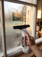 Aspirateur de vitres qui retire la buée d'une fenêtre de cuisine